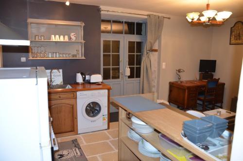 a kitchen with a sink and a washing machine at Studio Moncoeur in Le Blanc