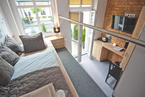 Kleines Zimmer mit einem Bett und einem TV in der Unterkunft Apartamenty Leszno in Leszno