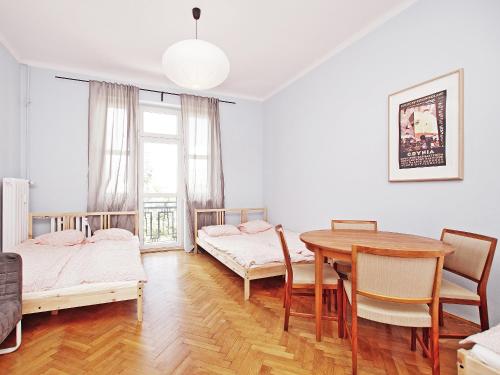 a room with two beds and a table and chairs at 3citygo - Hostel Gdynia 2017 in Gdynia