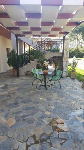 a patio with two benches and a table and stairs at Arcadian Apartments & Studios in Xiropigado