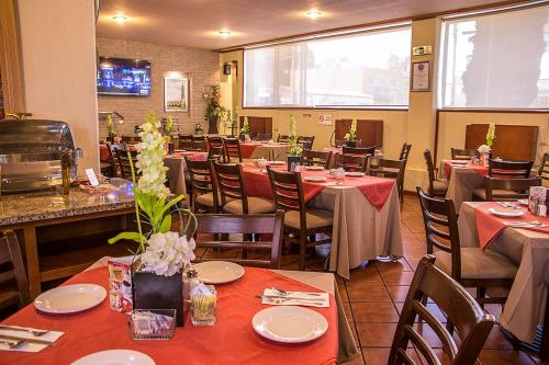 a dining room with tables and chairs in a restaurant at Gamma Durango Plaza Vizcaya in Durango