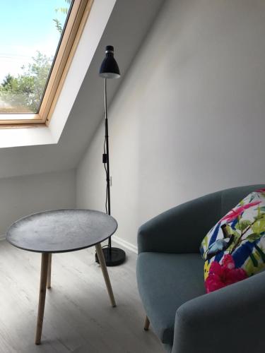 a living room with a couch and a table and a lamp at Fügekert - Bed&Wine in Zánka
