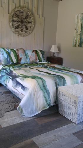 a bedroom with a bed with a blanket on it at Domaine de la Baie, Les Suites in Shawinigan