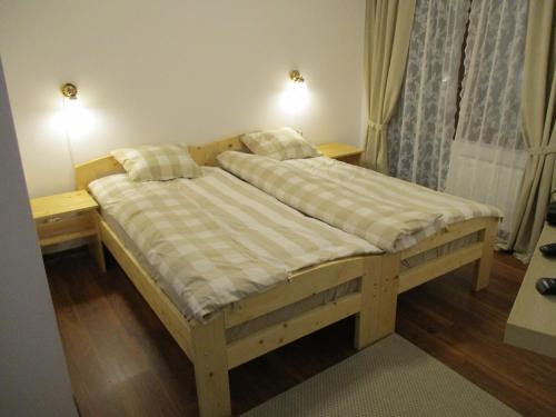 Cabana Poiana Galdei في Poiana Galdei: سرير خشبي في غرفة بها مواقف ليلتين