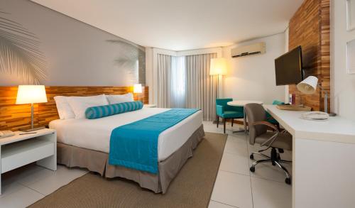 a hotel room with a bed and a desk at Best Western Premier Maceió in Maceió