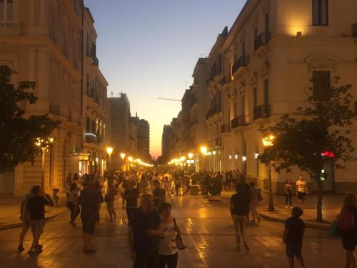 a crowd of people walking down a street at night at Casa della Nonna Pasqua in Taranto