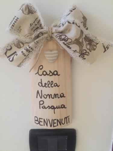 a white bag with writing on it next to a remote control at Casa della Nonna Pasqua in Taranto