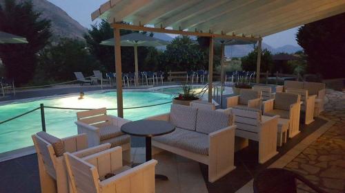 un gruppo di sedie e un tavolo accanto alla piscina di Hotel Iliana a Mandrotopos