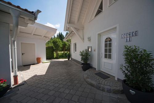 a white house with a door and a courtyard at Apartment Tinney in Kössen