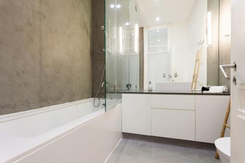 een badkamer met witte kasten en een glazen douche bij Baixa Tile Blue Two-Bedroom Apartment - by LU Holidays in Lissabon