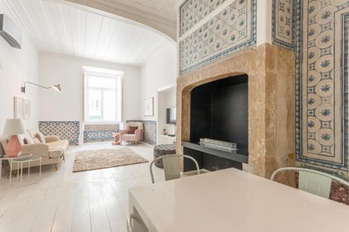 Il comprend un salon doté d'une cheminée et d'une télévision. dans l'établissement Baixa Tile Blue Two-Bedroom Apartment - by LU Holidays, à Lisbonne