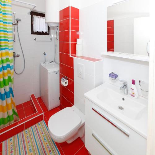 a bathroom with a white toilet and a sink at Apartments Stanic in Ravni