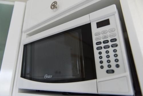 a white microwave oven sitting on top of a counter at The Lush in Willemstad