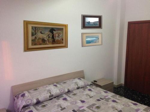 una camera da letto con letto e quadri alle pareti di B&B AL CANDIANO a Ravenna
