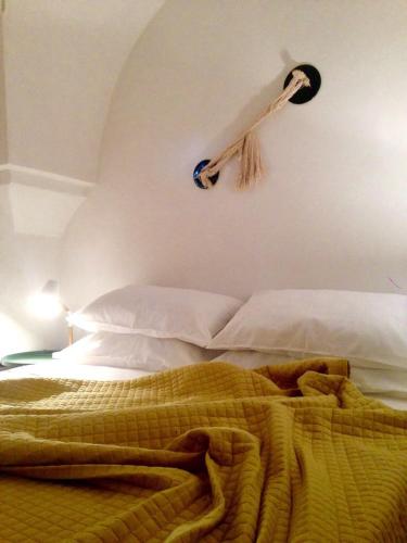 a bed with a baseball bat hanging on the wall at Corte dei melograni-Suite familiare-zona Ostuni in Montalbano
