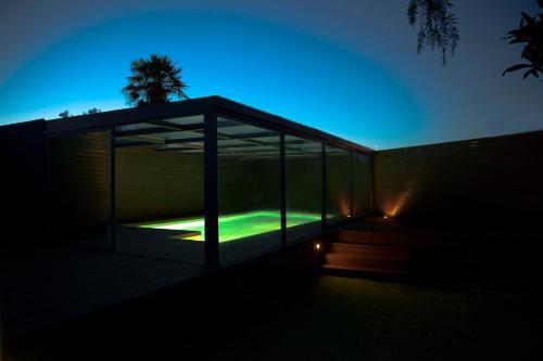a glass house with a green light in the dark at Apartment with Garden and Pool in Estoril