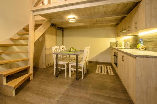 a kitchen with a table and chairs in a room at Apartamenty Winnicy Kresy II in Krakow
