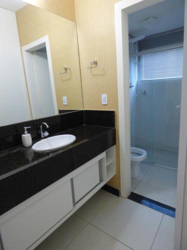 a bathroom with a sink and a mirror and a toilet at Mirante de Escarpas 1501 in Capitólio