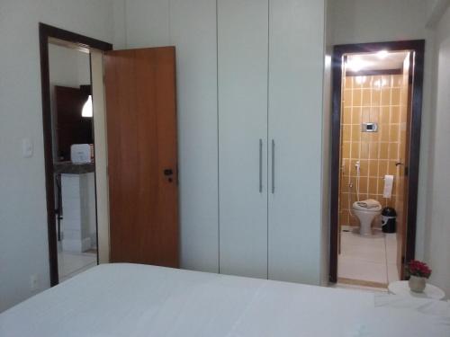 a bedroom with a bed and a bathroom with a toilet at Atlantic City Apart in Salvador