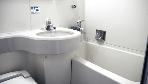 a bathroom with a sink and a bath tub at Hotel Premium Green Plus in Sendai