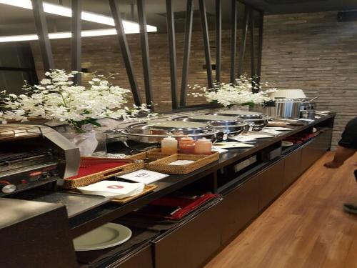 a buffet line in a restaurant with plates of food at Vella Suite Hotel in Suwon