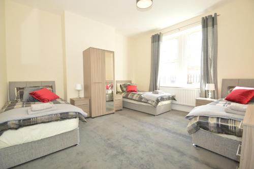 a bedroom with two beds and a window at Hyde Park Apartment in Gateshead