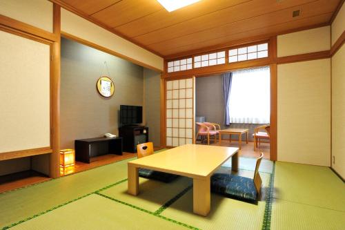 a living room with a table and a dining room at Niseko Hot Spring Ikoino Yuyado Iroha in Niseko