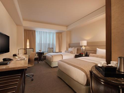 een hotelkamer met 2 bedden en een televisie bij Crimson Hotel Filinvest City, Manila in Manilla