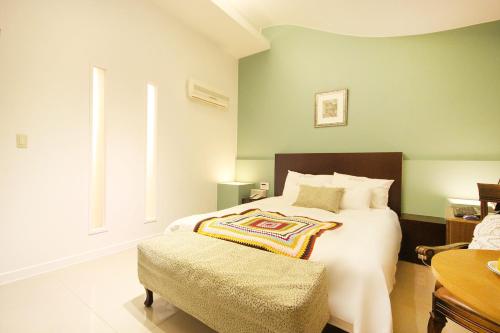 Charmant Hotel في موكبو: غرفة نوم بسرير كبير وكرسي