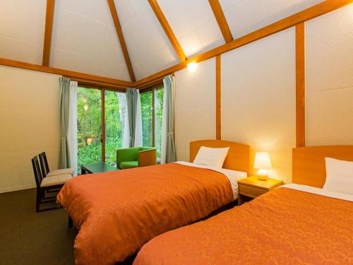 ein Hotelzimmer mit 2 Betten und einem Fenster in der Unterkunft Hotel Sunvalley Nasu in Nasu