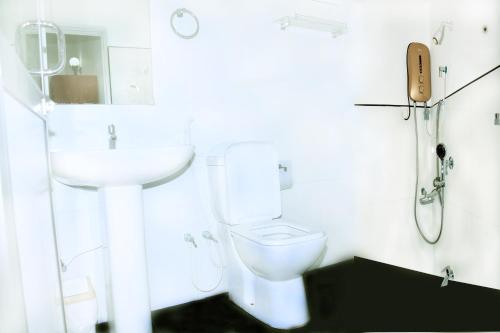 a white bathroom with a sink and a toilet at Bon Voyaage Tourist Inn in Trincomalee