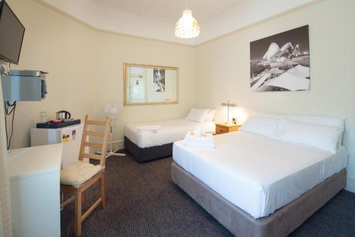 a hotel room with two beds and a tv at Neutral Bay Lodge in Sydney