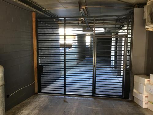 een garagedeur met metalen jaloezieën in een kamer bij Byron Beach House in Byron Bay