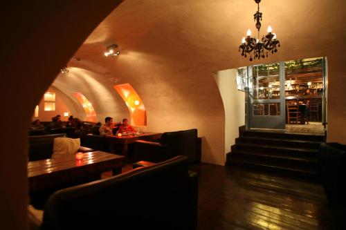 a restaurant with people sitting at tables and a chandelier at The Little House In Bakah in Jerusalem