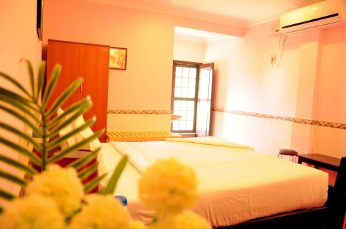 a hotel room with a bed and a table with flowers at Chettinaadu Narayana Vilas in Kānādukāttān