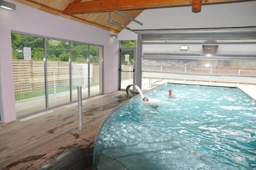 a swimming pool with two people in the water at Résidence Val de Roland in Luz-Saint-Sauveur