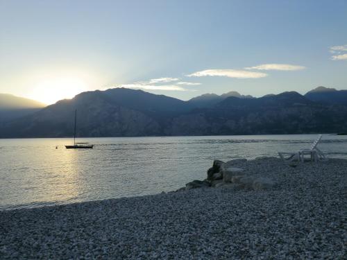 a boat sitting on the shore of a body of water at B&B Casa Sartori in Malcesine