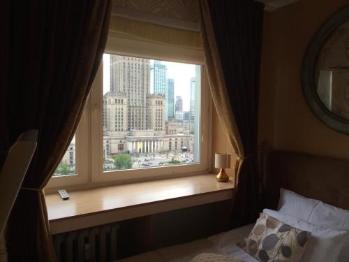 a window in a hotel room with a view of the city at Amica Apartment by WarsawResidence Group in Warsaw