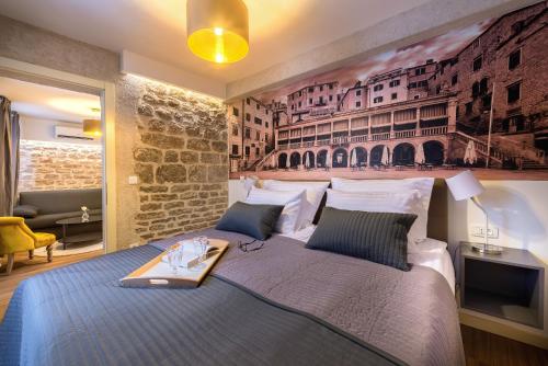 ein Schlafzimmer mit einem großen Bett und einem Gemälde an der Wand in der Unterkunft Fenice Palace in Šibenik