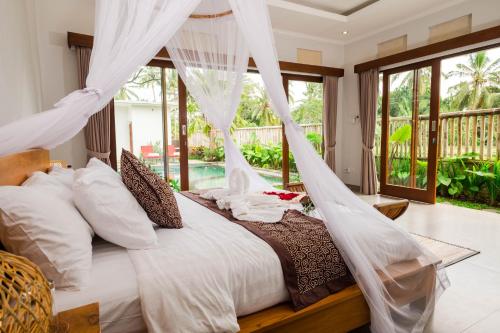 a bedroom with a bed with mosquito nets at Laba Ubud Villa in Ubud
