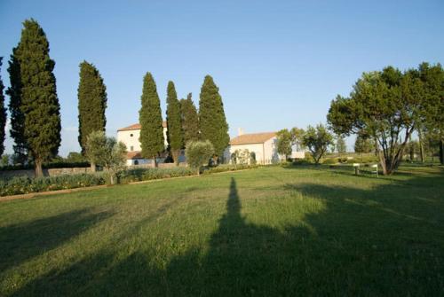 a grassy area with trees and houses at Terrarossa Golf Resort in Porto Ercole