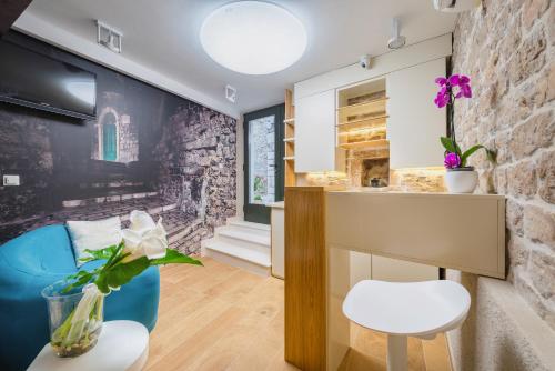 a living room with a stone wall and a table and chairs at Fenice Palace in Šibenik