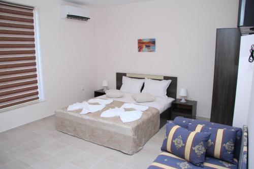 Un dormitorio con una cama con toallas. en CAPUCCINO GUEST APARTMENTS - FREE PARKING and Wi-Fi, en Sunny Beach