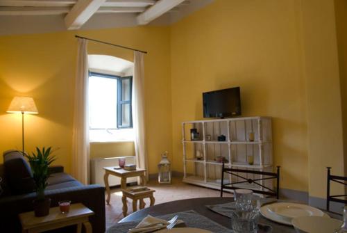 - un salon avec un canapé et une télévision dans l'établissement Fonte del Lupo, à Porto Ercole