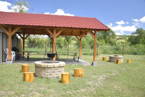 a gazebo with a grill and wooden posts at Fortuna Apartmanházak in Bogács