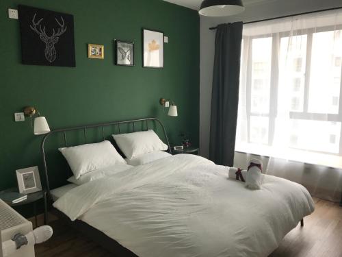 a bedroom with a bed with a teddy bear sitting on it at Ma Cherie Homestay in Shanghai