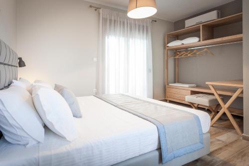 a bedroom with a white bed and a desk at Enalia Villas in Ierissos
