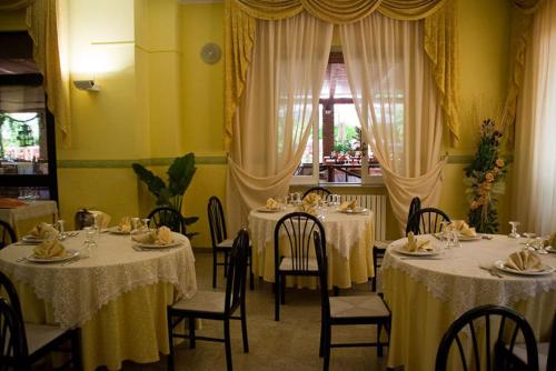 comedor con mesas y sillas y ropa de cama blanca en Hotel Ristorante Solari, en Briatico