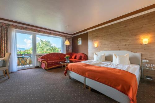 a hotel room with a bed and a large window at Parkhotel Tannenhof in Oy-Mittelberg