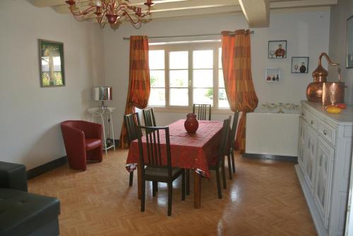 a dining room with a red table and chairs at La Ferme Fortin in Gensac-la-Pallue